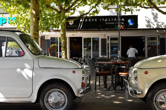Außenterrasse von Arte Italiana mit klassischen Fiat 500 und Blick auf den Eingang